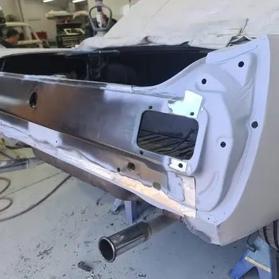 Rear quarter panel stripped to bare metal, with new steel let into the lower section