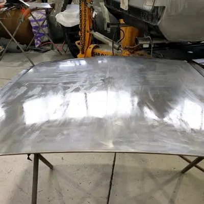 Mustang bonnet stripped to bare metal on stands in the workshop