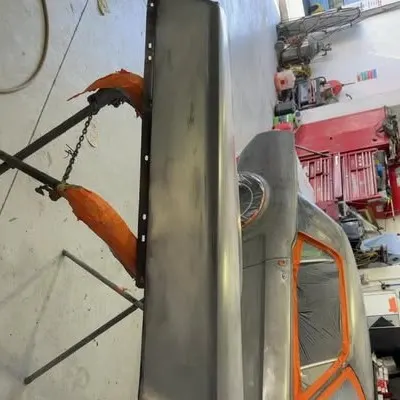 Bare-metal Mustang panel on a stand, ready for primer