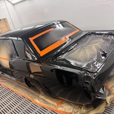 Three-quarter view of the freshly painted Mustang in the spray booth