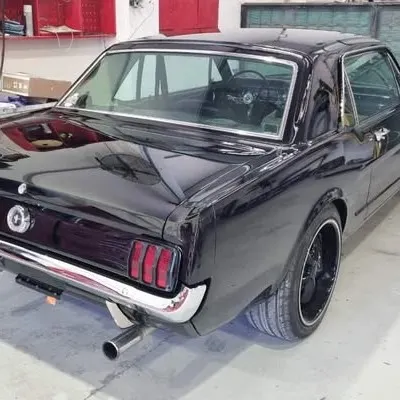 Rear three-quarter view of the finished Mustang, showing the tri-bar tail lights