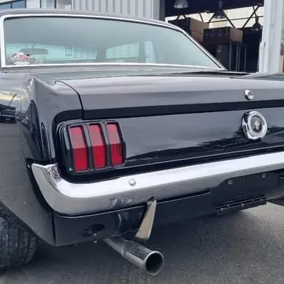 Close-up of the tail lights, chrome bumper and exhaust on the finished Mustang