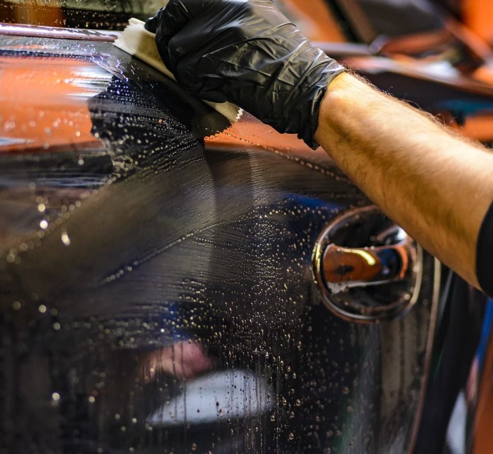 Technician polishing a freshly refinished car panel